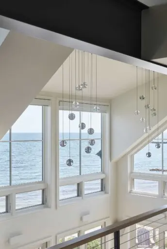 House on the Bluff Hero Interior Loft Water View Oceanfront Bubble Lights Steel Beam Modern Contemporary